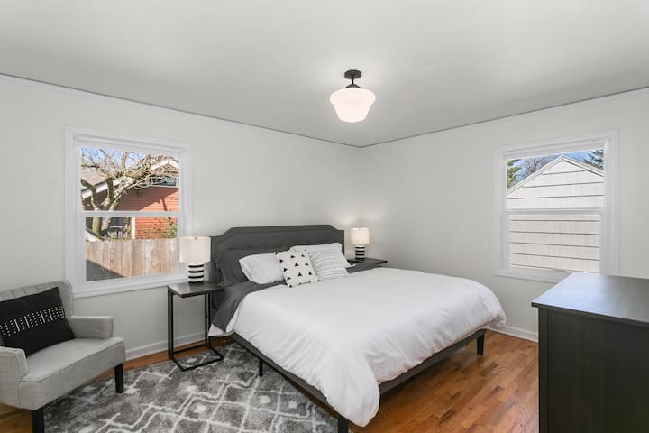 غرفة نوم في الطابق الرئيسي بسرير كبير يطل على الفناء الخلفي.