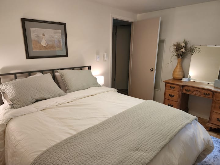 The main floor bedroom has a queen bed and luxury bedding for a restful night.