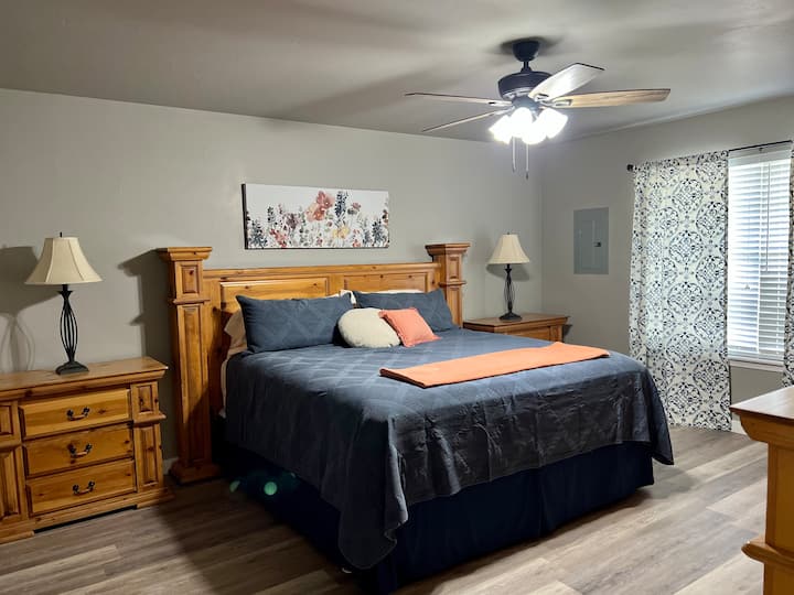 Master bedroom w/ king bed, smart TV, double sinks, large walk-in closet, & shower/tub combo.