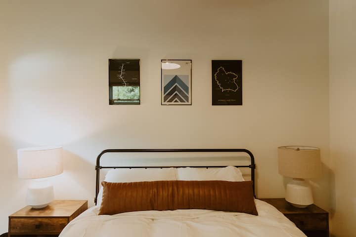 Our bunkhouse features a queen bed, with reminders of nearby trails mounted on the walls.