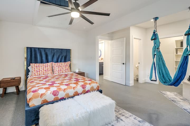 Dormitorio principal con cama tamaño queen, bañera de inmersión y columpio de yoga 