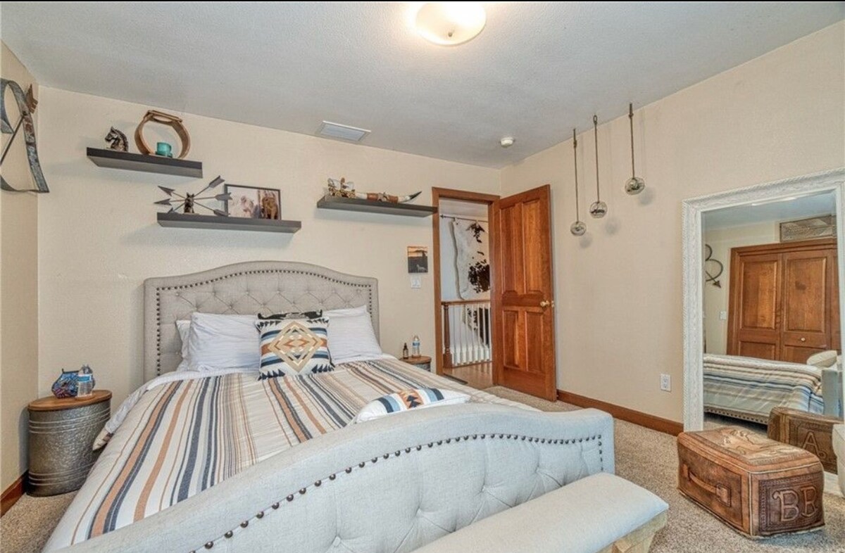 Спална соба на скали со брачен кревет (широк 150-179 см) и лизгачка стаклена врата со пристап до балкон.