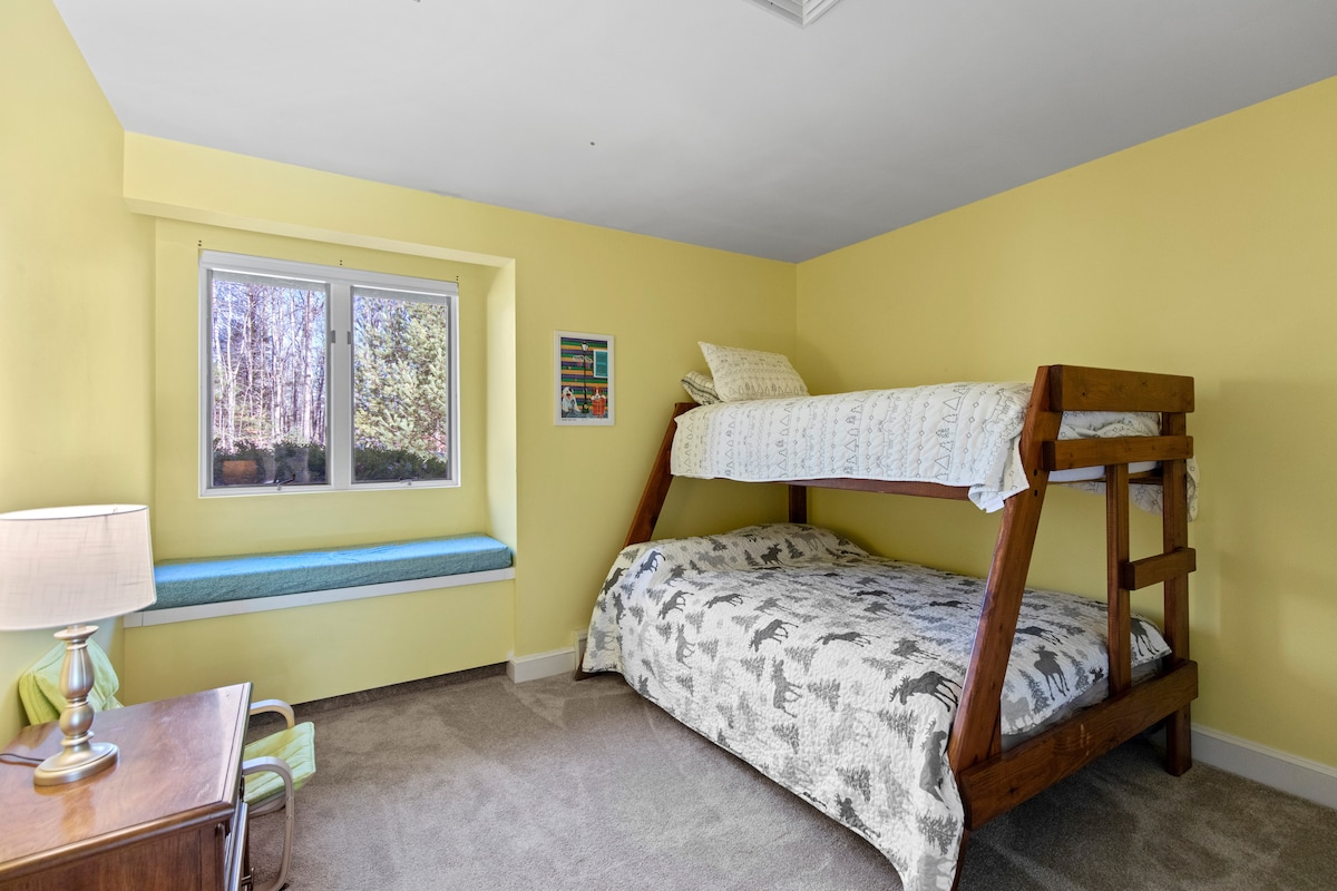 La chambre 3 dispose de lits superposés (matelas double en haut et matelas complet en bas).  La chambre 3 offre une vue sur la maison et l'allée.