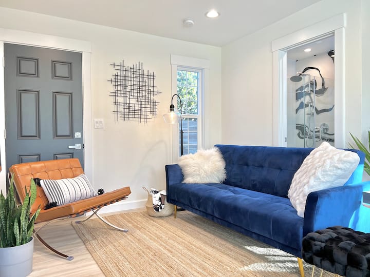Downstair living room,  a barcelona leather lounge chair, a sofa for reading, watching TV, as well as sleeping when it is flattened to a single bed. 