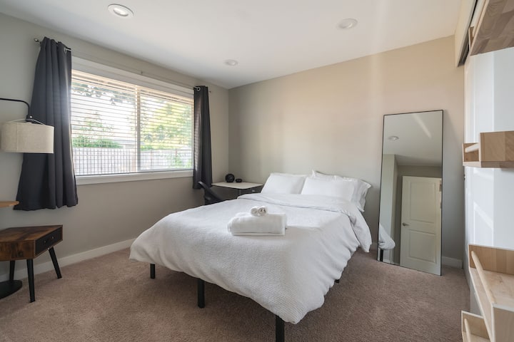 Модерен имот - спална соба со поглед кон дворот и двоен кревет и мал работен простор