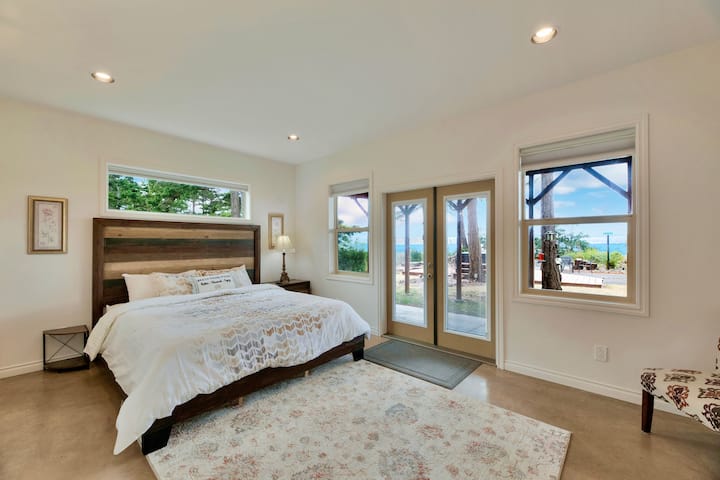 Cama tamaño king californiana en la suite de abajo. A poca distancia del patio trasero con vistas al mar.