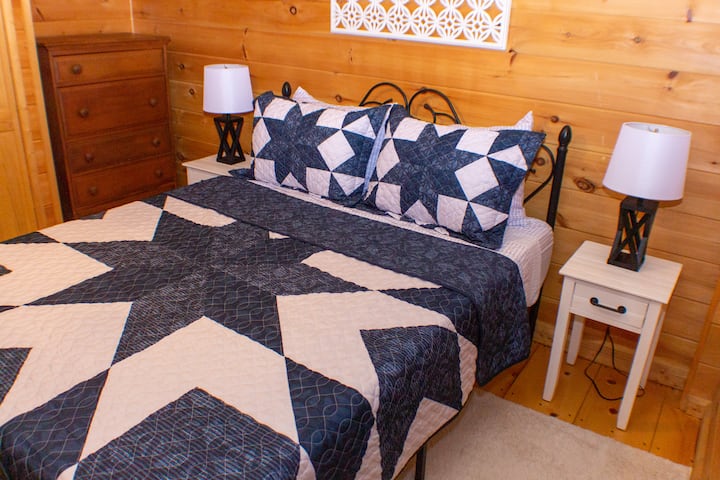 Lower level bedroom.  Queen bed.  Closet has luggage rack, hangers, extra pillows and blanket. Door to deck with hot tub.  Heating unit near floor.  