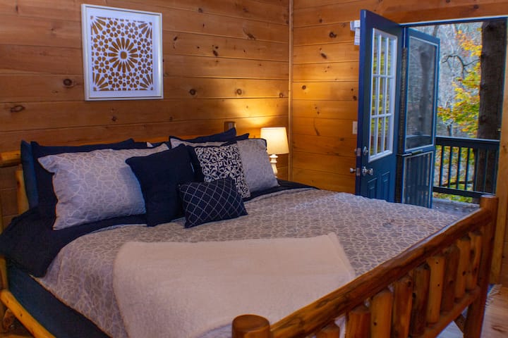 Master bedroom - door to private deck.  King sized bed.  Large screened tv.  Closet has luggage rack, iron, ironing board.  