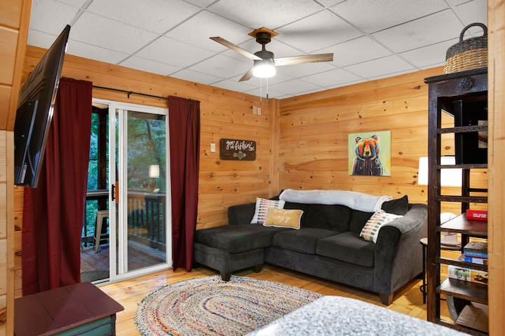 Lower level living room as seen from kitchenette.  Sliding door leads to hot tub deck.  Games and puzzles on the shelf. Tv has Roku, just sign in with your info. Lower level also has full bath and bedroom with queen bed.  