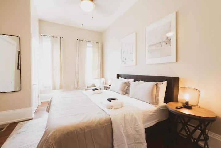 تحتوي الغرفة البيج على مرآة حائط كاملة الطول.