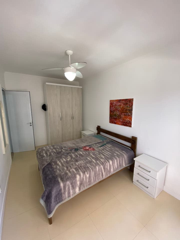 Spálňa so stropným ventilátorom a prístupom na balkón s výhľadom na ulicu Pindorama.