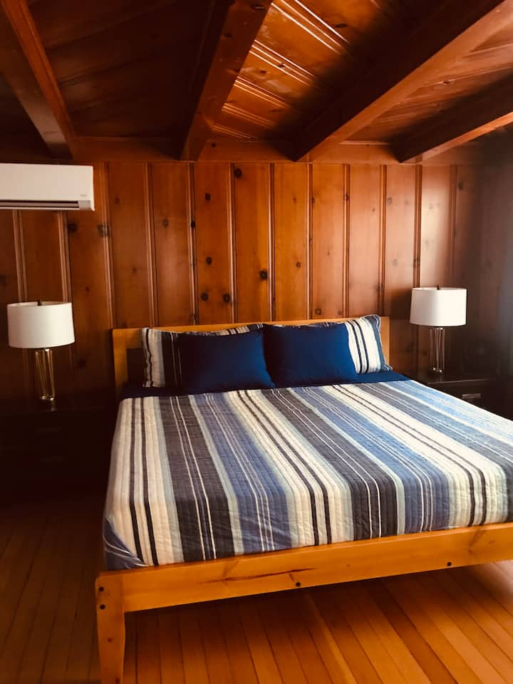 Vista al dormitorio principal con cama tamaño king y baño privado.