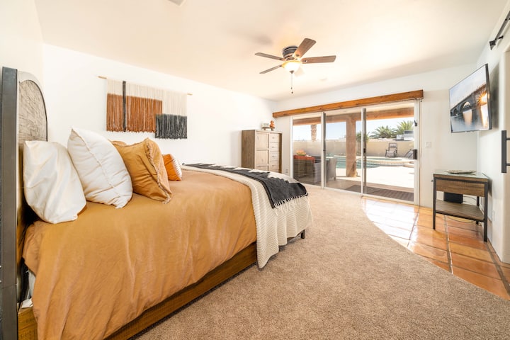 View of the primary bedroom from the door. 
The bedroom features blackout curtains for those mornings you want to sleep in, a smart TV and Google home to play your favorite tunes.