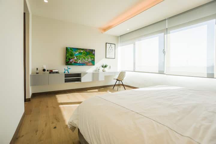 Главната спалня има суперголямо двойно легло и 65- инчов смарттелевизор.