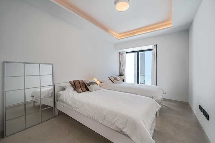 Chumba pacha, vitanda 2 vya mtu mmoja, mapazia meusi yenye madirisha marefu ya ghuba yanayoangalia maeneo ya jumuiya. Chumba hiki pia kina wodi jumuishi. 