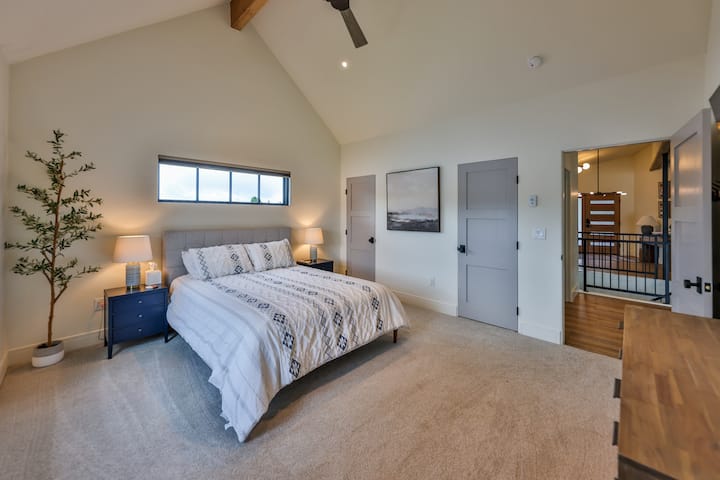 Upper level bedroom with a queen bed and desk space.