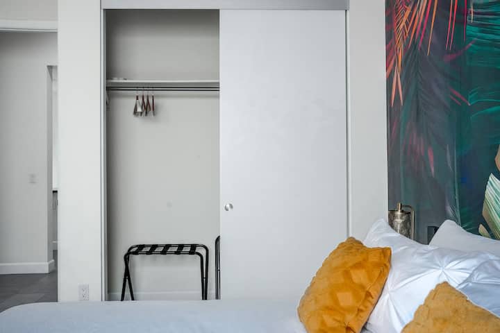Este dormitorio de invitados tiene un cierre adecuado con perchas y un soporte para equipaje, ¡perfecto para que tus huéspedes desempacen cómodamente y se mantengan organizados!