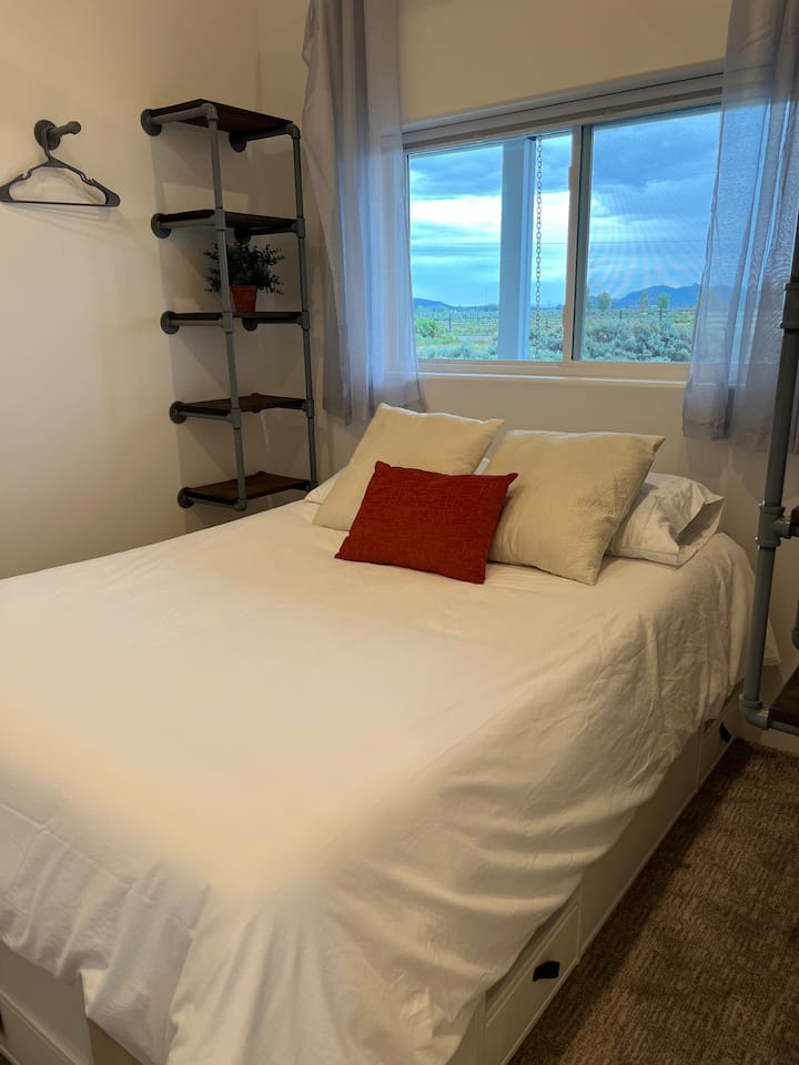 Dormitorio privado pequeño con una cama tamaño queen.