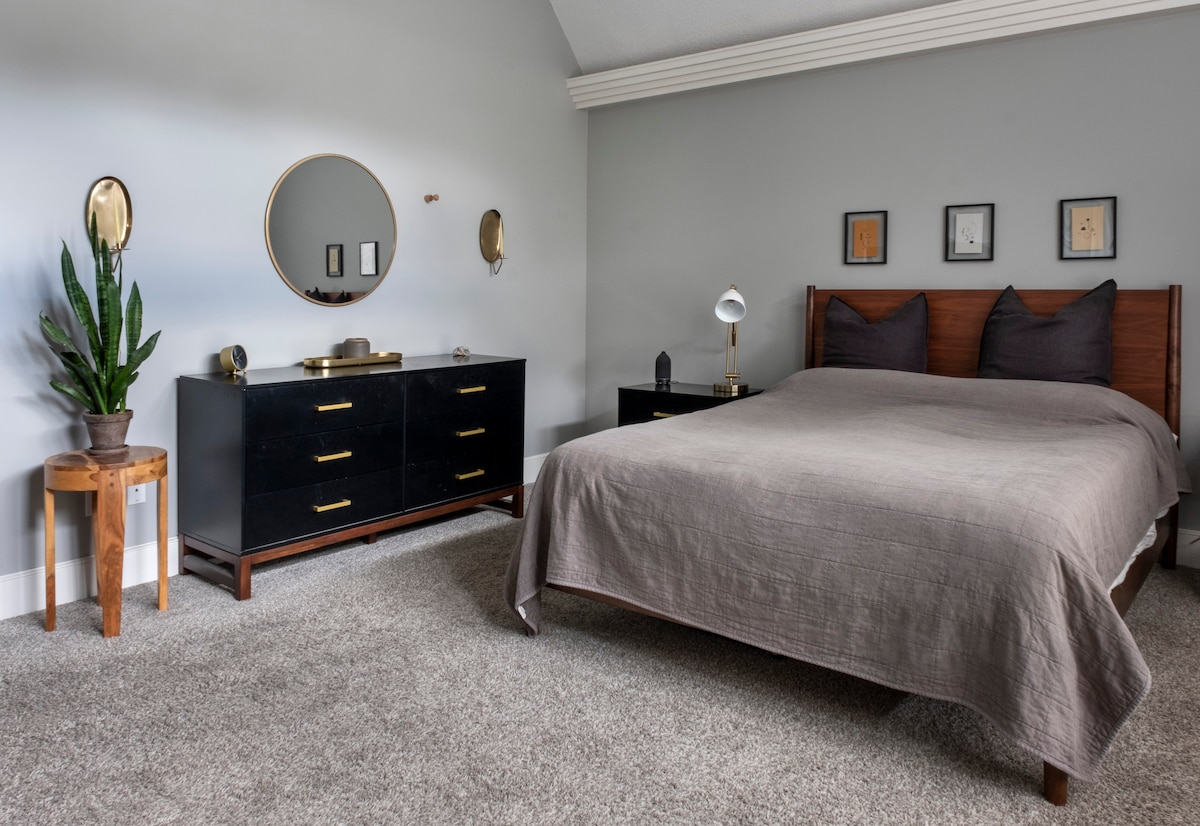 Glavna spavaća soba s bračnim krevetom i modernim namještajem. Ova soba ima kauč, stolić i dovoljno prostora za odjeću, uključujući dva velika ormara.