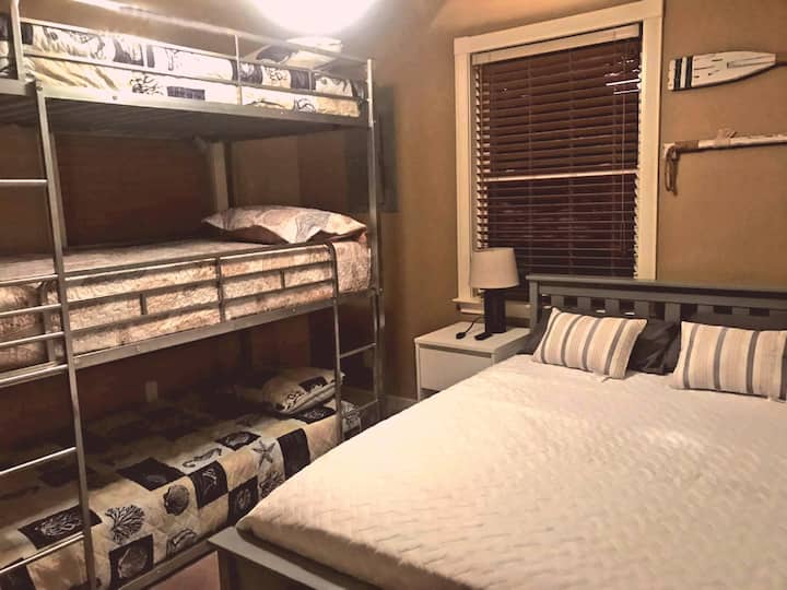 חדר שינה עם מיטה מלאה אחת ושלושה תאומים (מיטת קומתיים). טלוויזיה חכמה עם כבל.