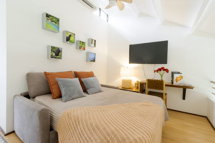 Sala de estar con TV + área de trabajo que se transforma en una segunda habitación con sofá cama, súper confortable de Memory Foam.