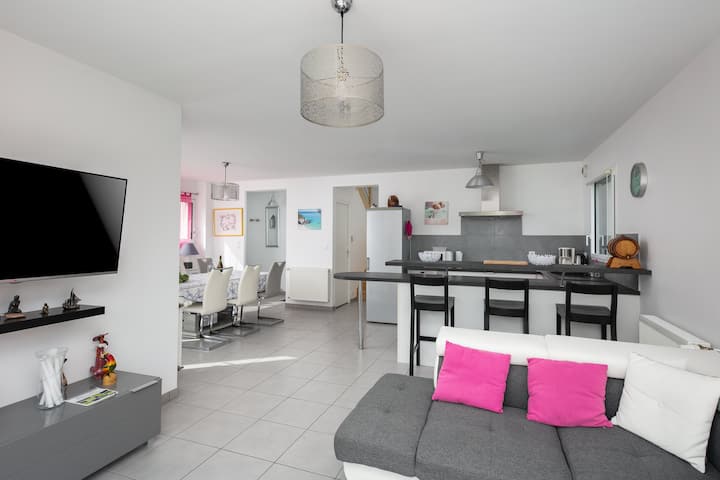 Espace salon avec canapé, table basse, télévision et accès à la terrasse