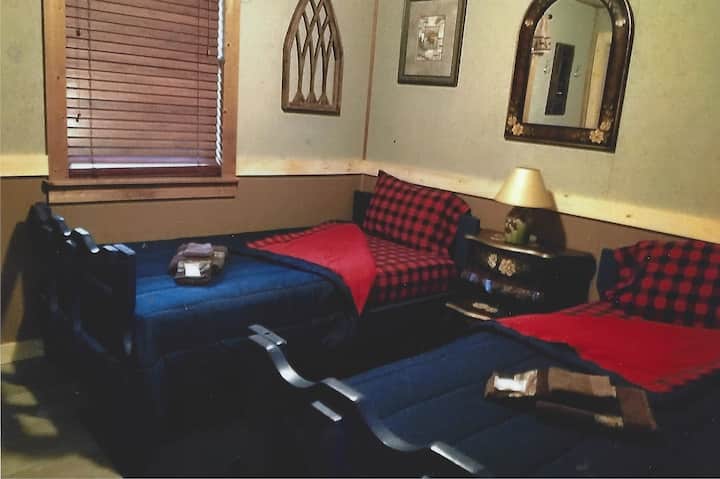 غرفة النوم الأولى في الطابق العلوي مع سريرين صغيرين. 