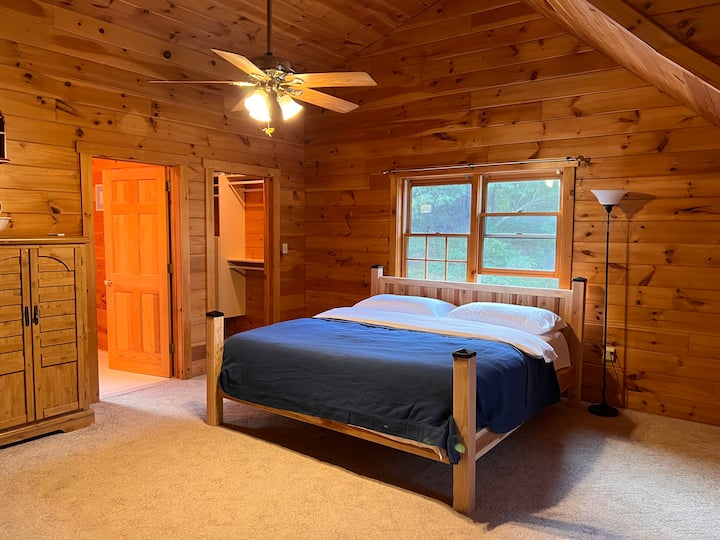 King-sized master bedroom in our Poconos retreat, featuring walk-in robes, a full ensuite bathroom, and equipped with a comfortable mattress, plush pillows, and luxurious linens.