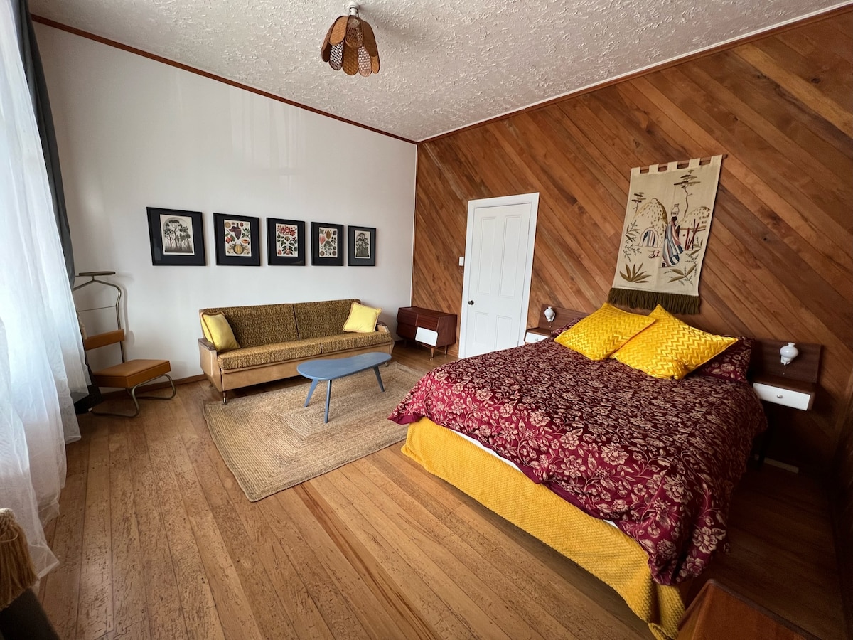 El dormitorio principal tiene una cama queen con una impresionante cabeza de cama Rimu restaurada y una suite de dormitorio a juego junto con un sofá que se convierte en una cama doble.  
