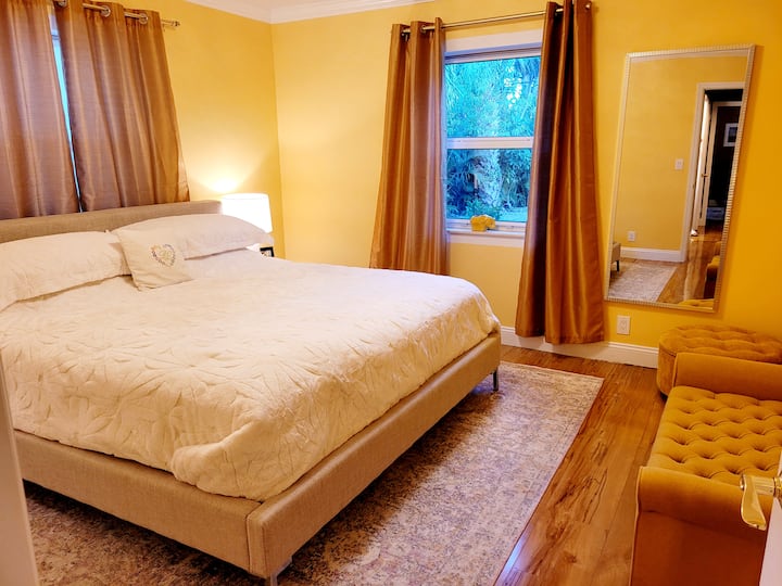 חדר שינה 1 עם מיטת קינג, פרטיות ונופי גן מכל חלון.