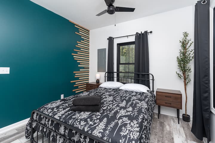 La chambre verte avec matelas Queen en mousse à mémoire de forme, située à côté de la salle de bain chic.