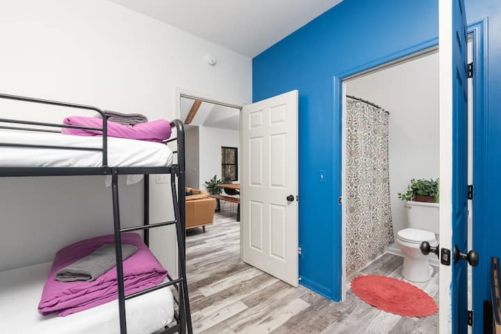 La chambre avec lits superposés bleus, avec des matelas en mousse à mémoire de forme, à côté de la salle de bain Jack-n-jill.