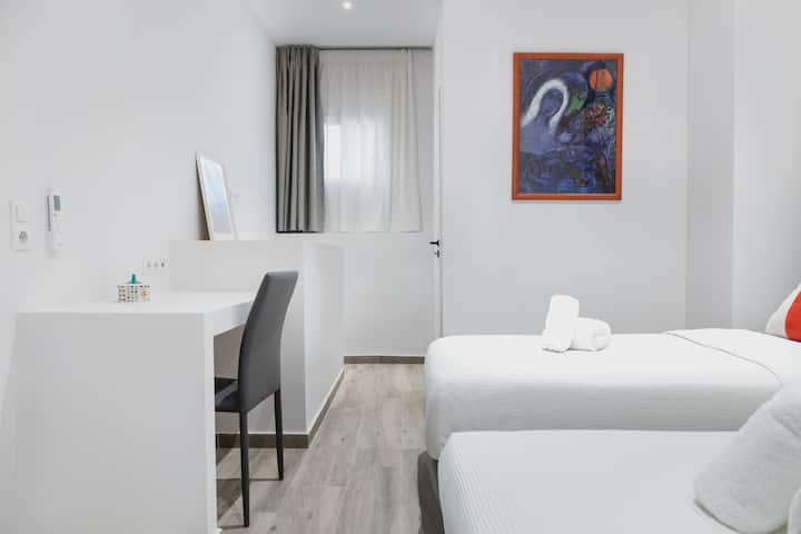 Espacio de trabajo y dormitorio con 2 camas individuales.