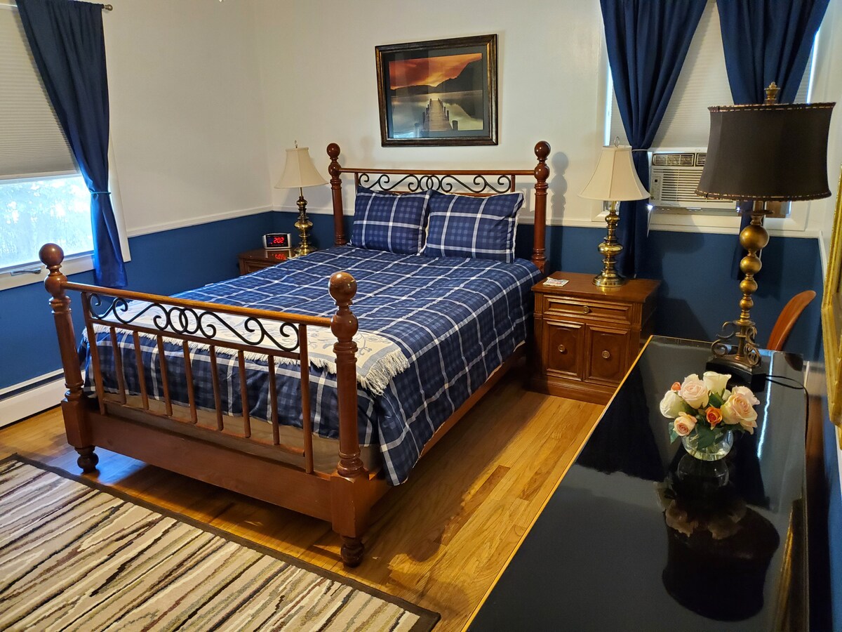 Main front bedroom with queen bed, ceiling fan and Roku television