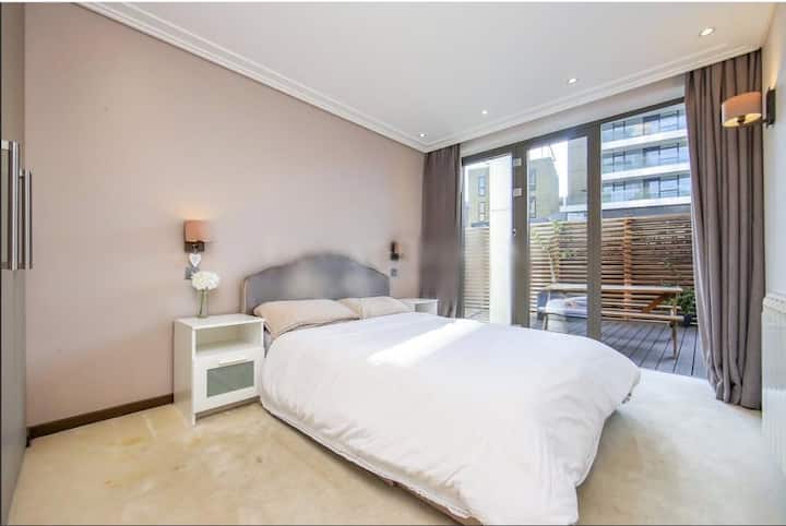 Dvojlôžková spálňa pre hostí s oknami od podlahy až po strop, ktoré poskytujú množstvo prirodzeného svetla 