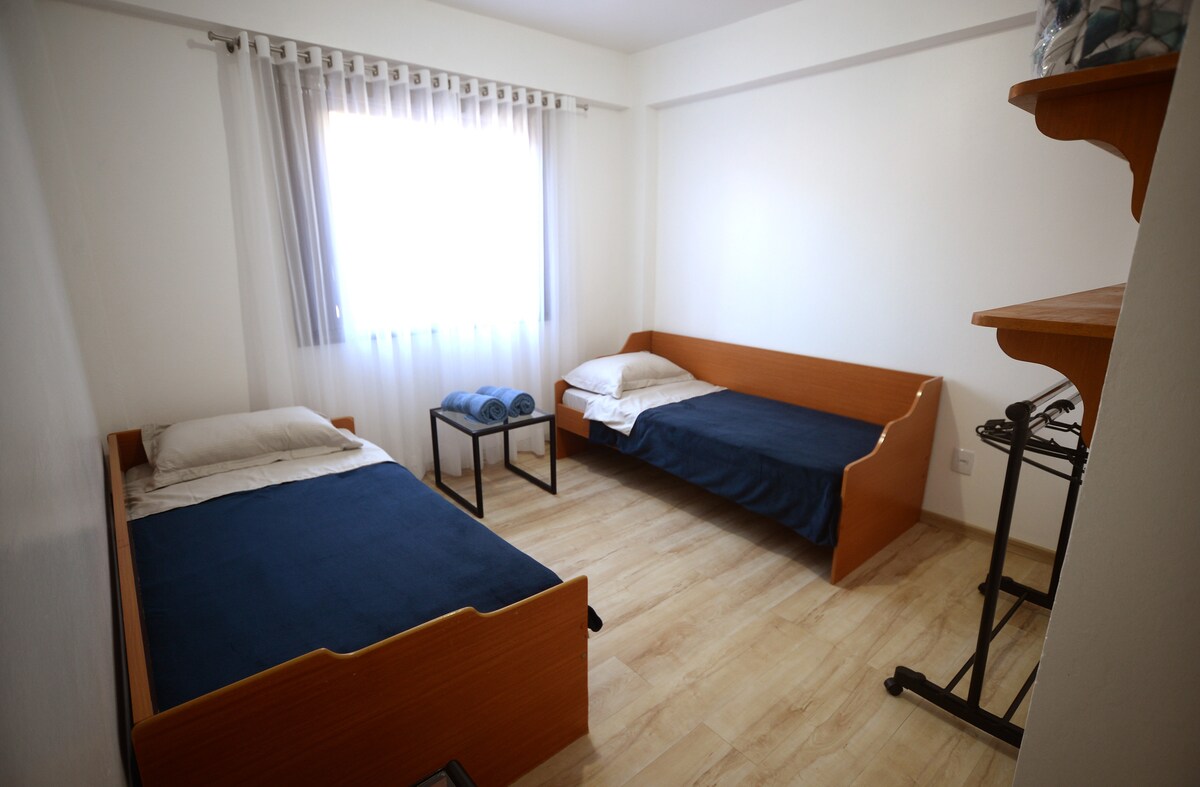 Dos cómodas camas individuales con mesita de noche como soporte