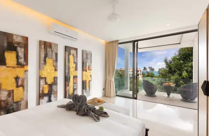 Open-plan living space with decorative Asian screens, modern furniture and seamless indoor-outdoor flow to the pool terrace