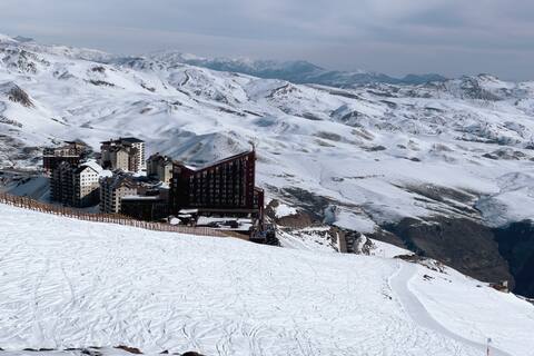 Spacious depa with ski-in-out views, snowy valley.