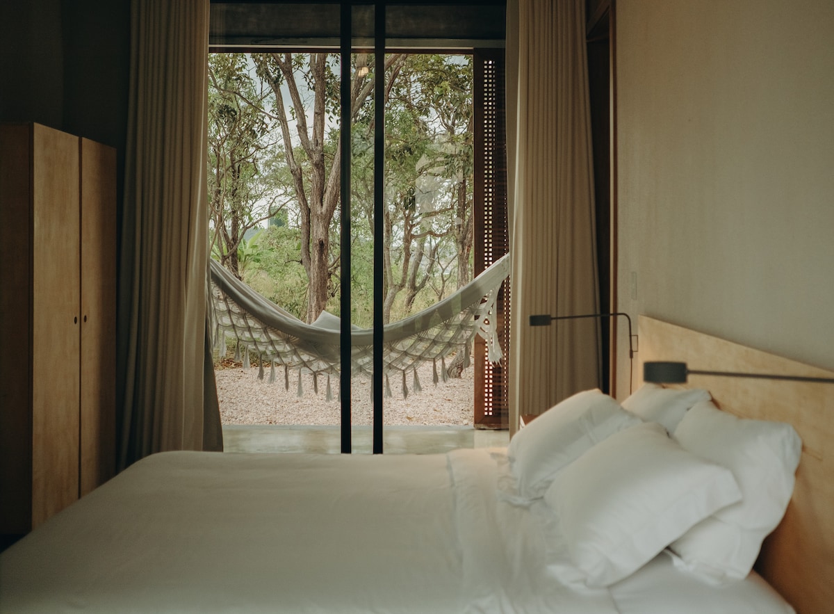 Quarto da Casa Poema e varanda interna, com vista para a parte frontal da casa. 