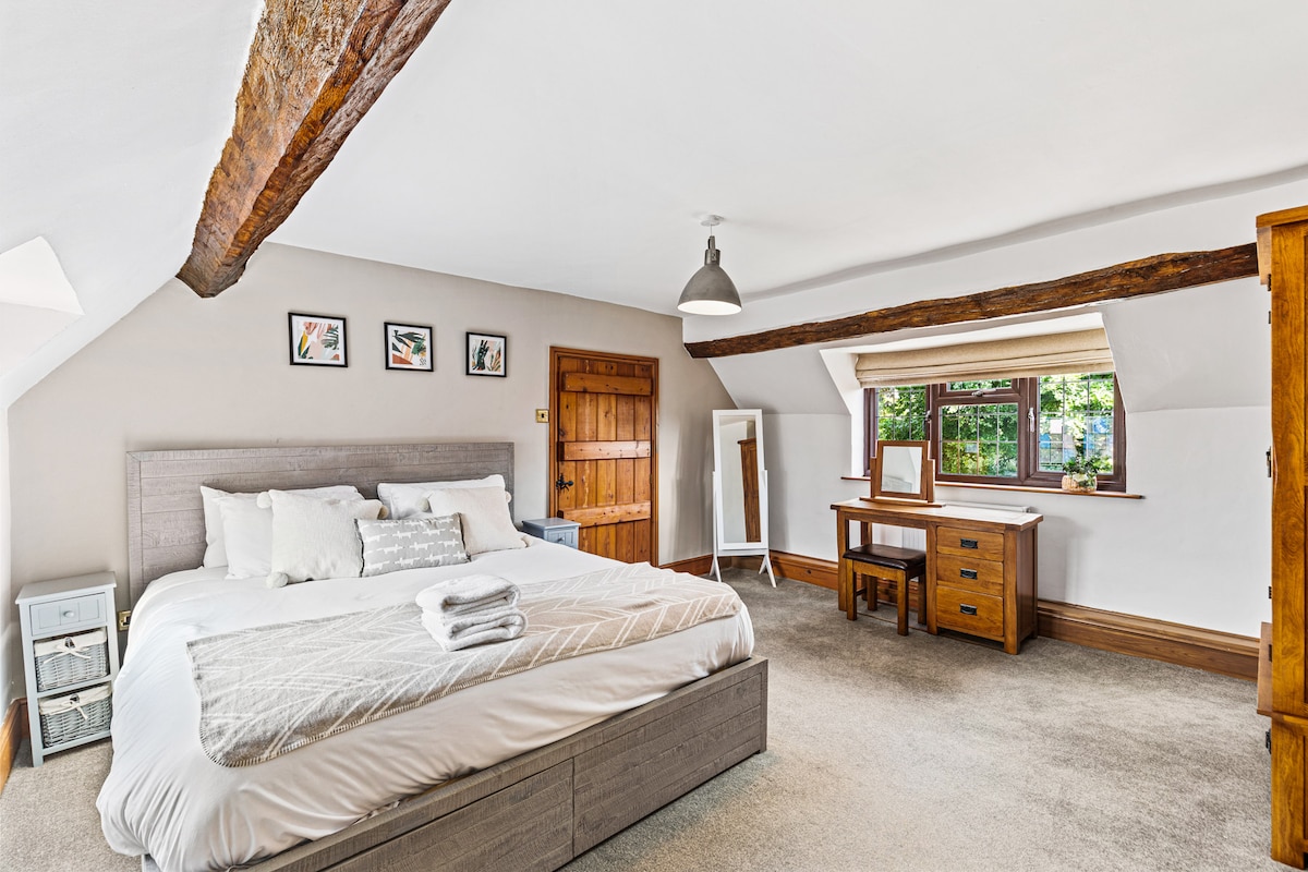 Amplio dormitorio principal en la planta superior ️ con una cama tamaño super king y baño privado con ducha, inodoro y lavabo. Se proporcionan ropa de cama, toallas y artículos de tocador frescos para tu estancia. ✨