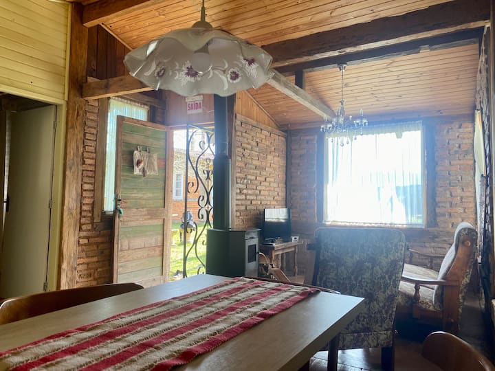 Jedálenský stôl a obývacia izba s kozubom.