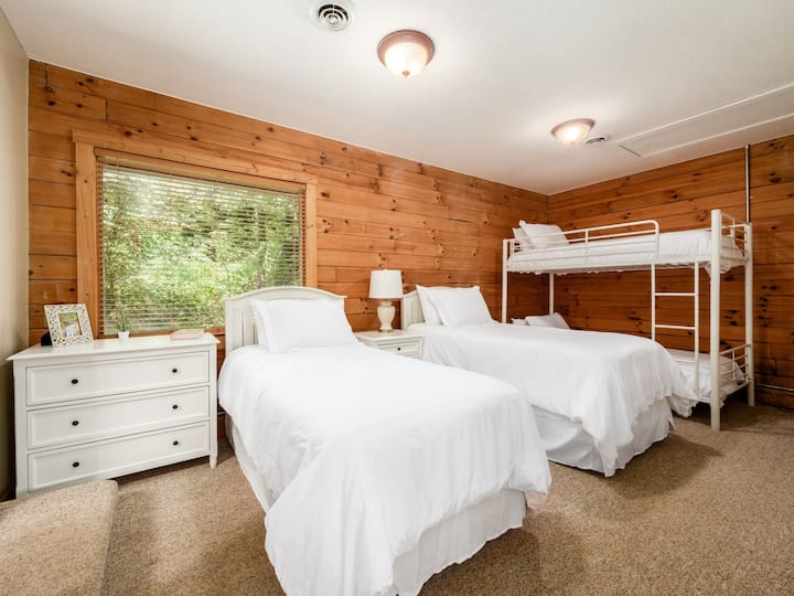 Retiro rústico: relájate y desconecta en este acogedor cuarto dormitorio, con una cómoda cama tamaño queen, una litera doble sobre completa y cálidos detalles de madera. 