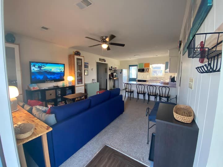 منظر من الباب الأمامي يظهر المطبخ مع مقاعد مضادة بجوار غرفة المعيشة. 