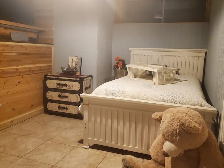 Dormitorio secreto con cama doble, TV y área de trabajo.