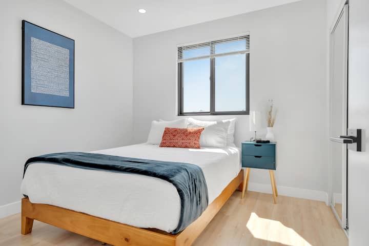 Bedroom 5: Queen bed with window, closet space, and nightstand.