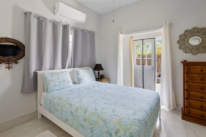 Двойна спалня с прилежащ санитарен възел и достъп до заден двор и душ на открито.