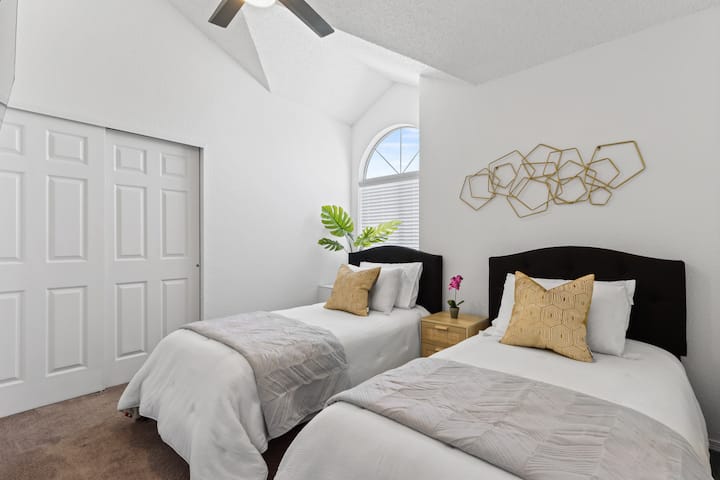 Svetlá 4. bonusová izba na poschodí má dve samostatné postele, luxusnú posteľnú bielizeň a 55-palcovú inteligentnú televíziu s klenutým stropom, diaľkovým stropným ventilátorom a svetlom, stojanom na batožinu a otvorenými dverami.