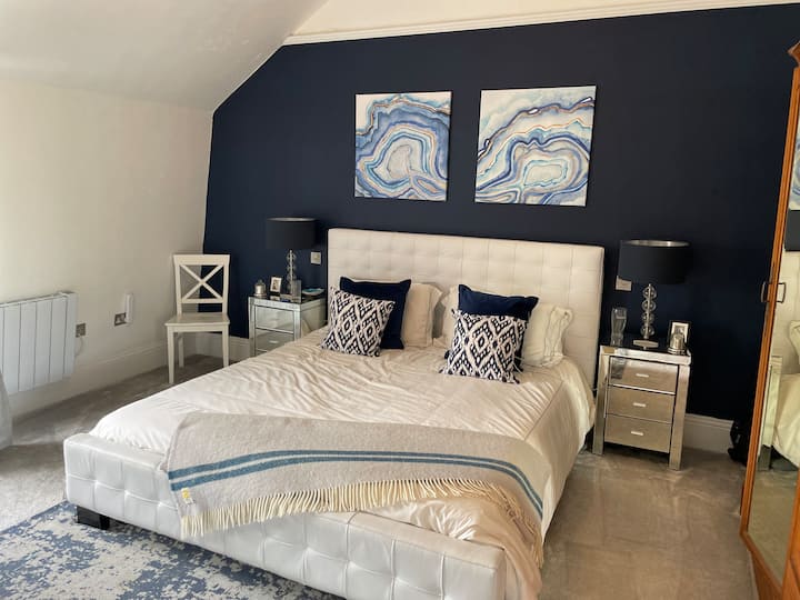 Kjo është një dhomë gjumi e madhe me një gardërobë shumë të madhe, sirtarë dhe 2 karrige. Krevati SUPERKING ka një dyshek luksoz mbështetës.