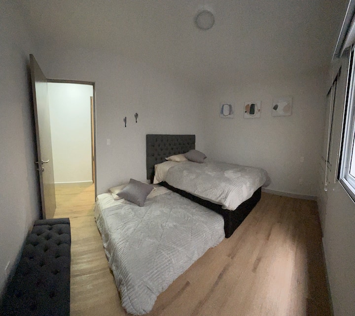 ห้องนอนที่สองพร้อมเตียงจิงโจ้ เตียงควีนไซส์ทั้งสองเตียงตู้เสื้อผ้าและท้ายรถ