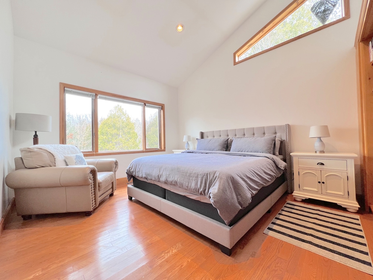 La biblioteca también es un dormitorio espacioso con una cama tamaño king, mucha luz natural y una gran silla cómoda para sentarse y disfrutar de tu libro favorito.